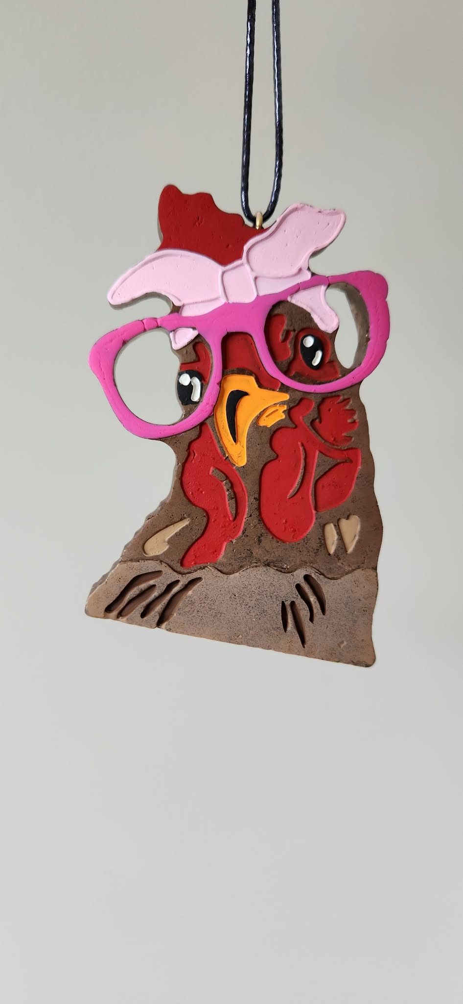 Cartoon chicken keychain ornament with red, pink, and brown details