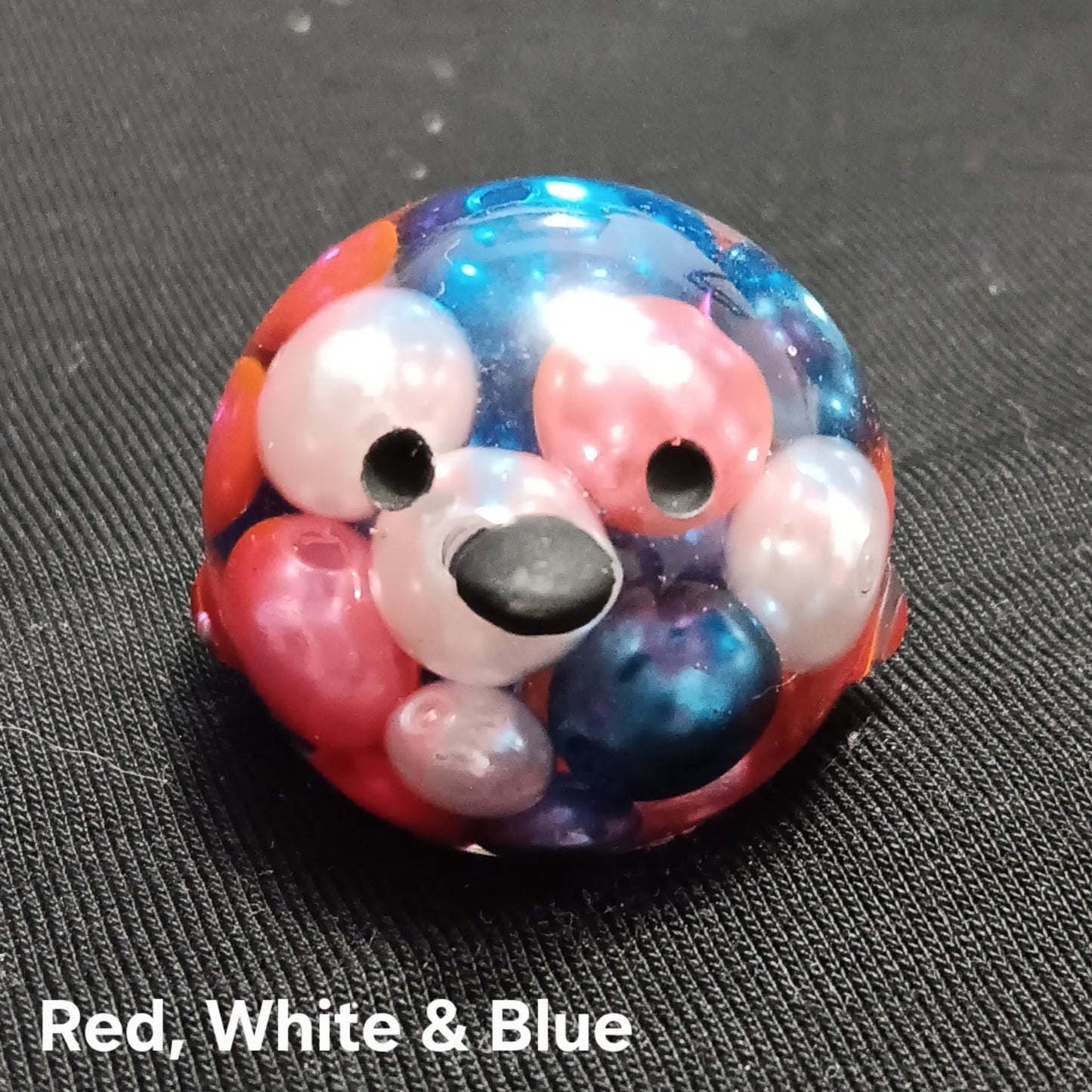 Mini pet bird toy, red white and blue with black beak and round eyes