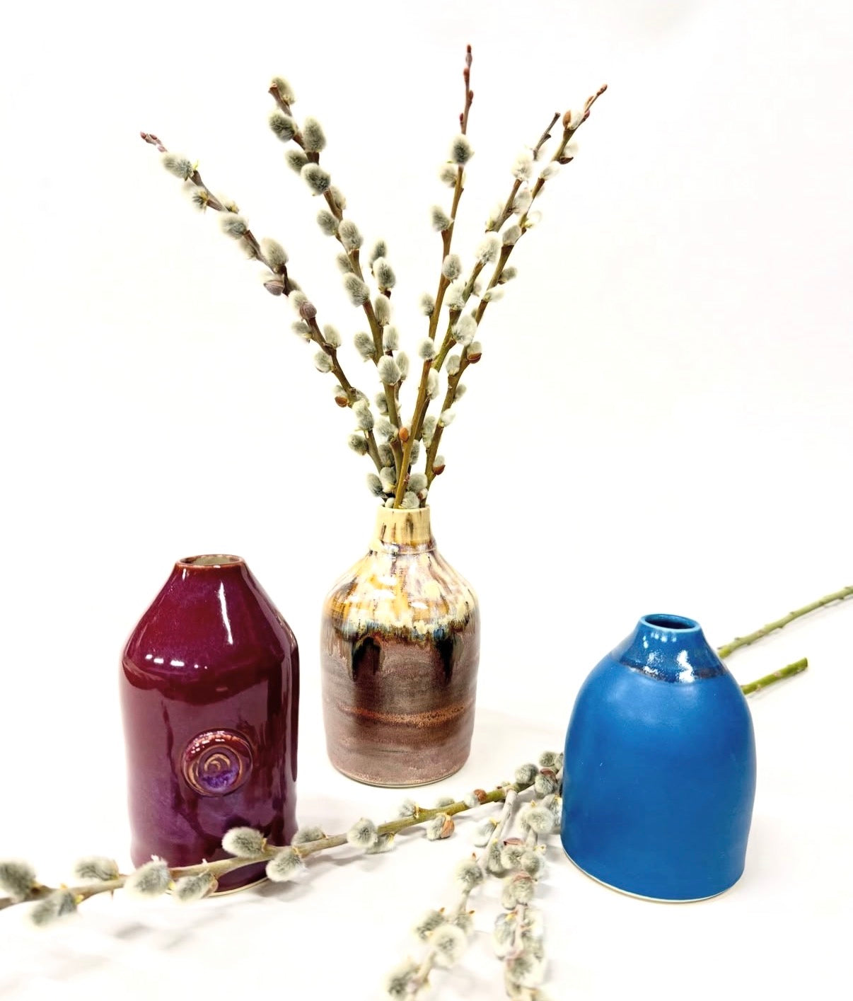 Button-swirl ceramic vases set: maroon, tan, and blue glossy glazed