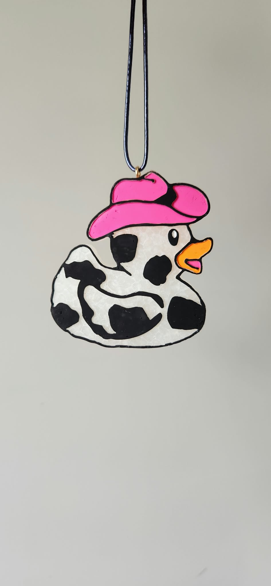 Cowboy duck charm with pink hat, black-and-white spotted duck, dangling necklace