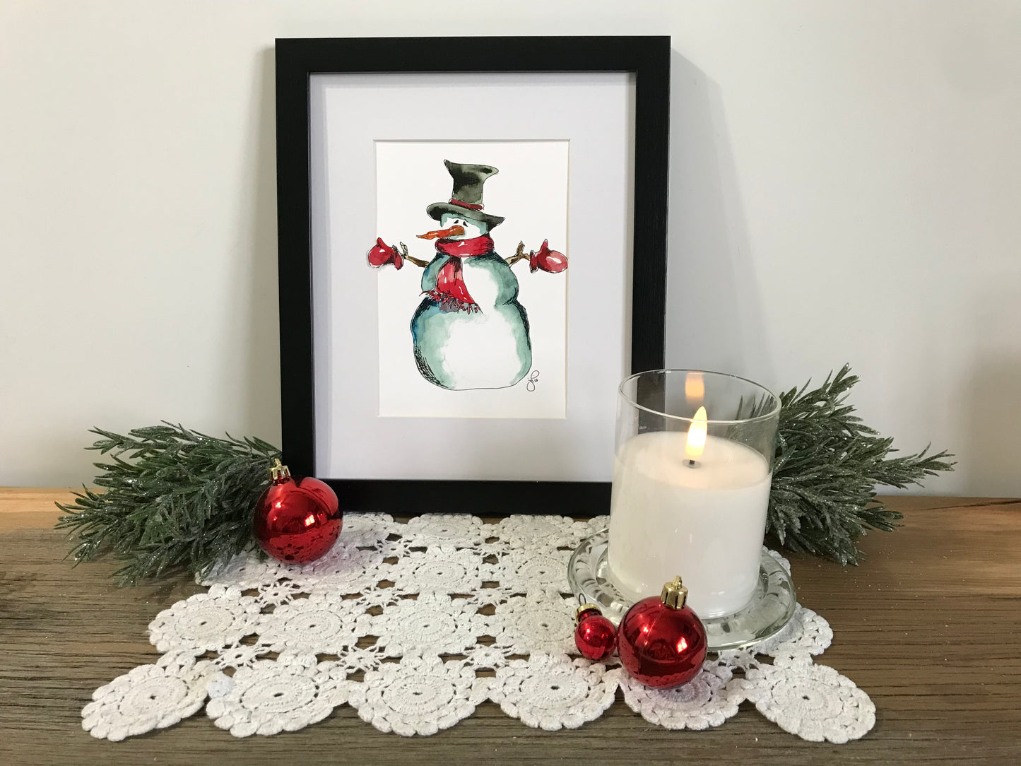 Framed red mitten snowman illustration with red arms and green top hat