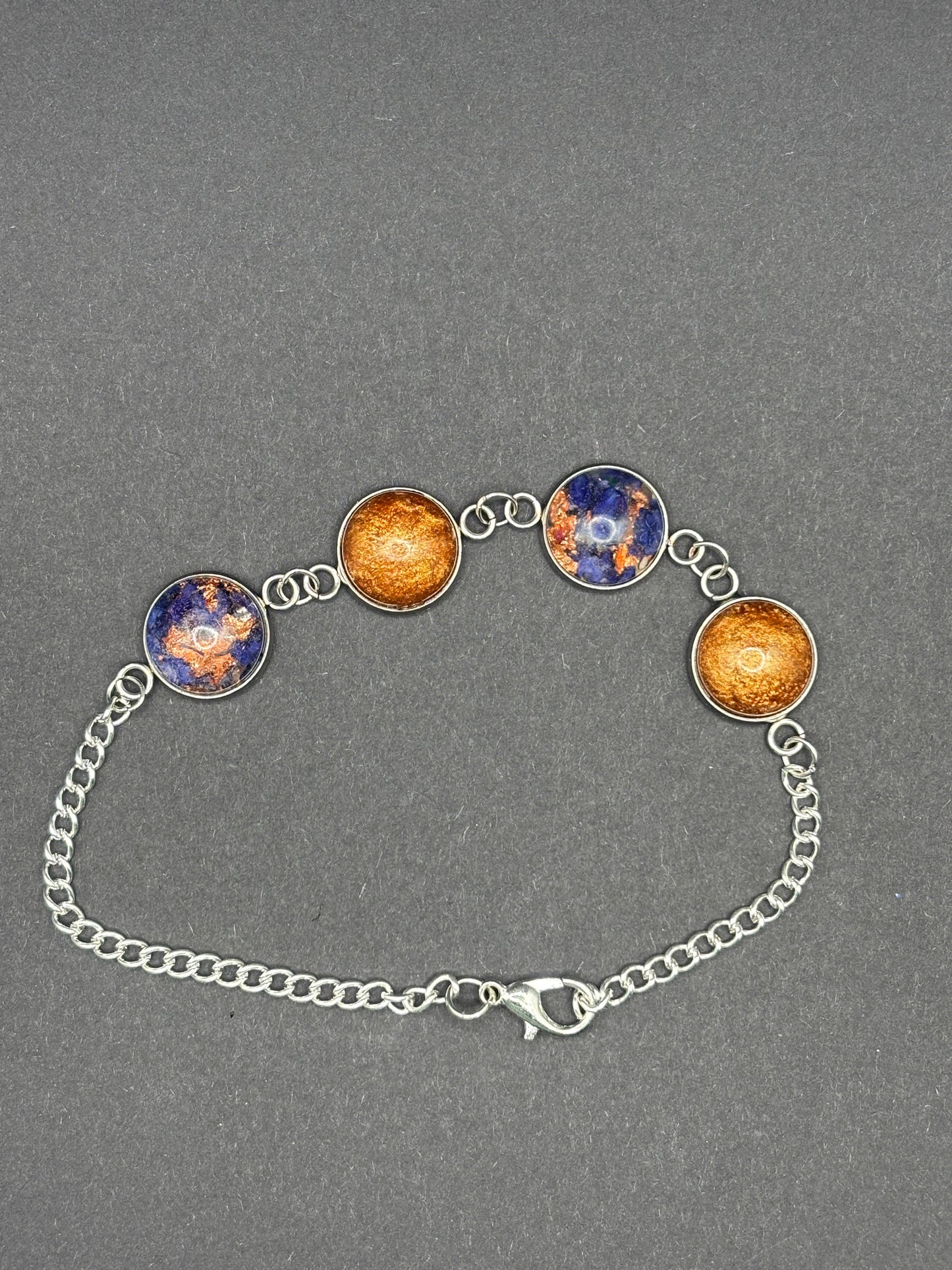 Copper-toned charm bracelet with blue cabochon discs and silver chain, toggle clasp