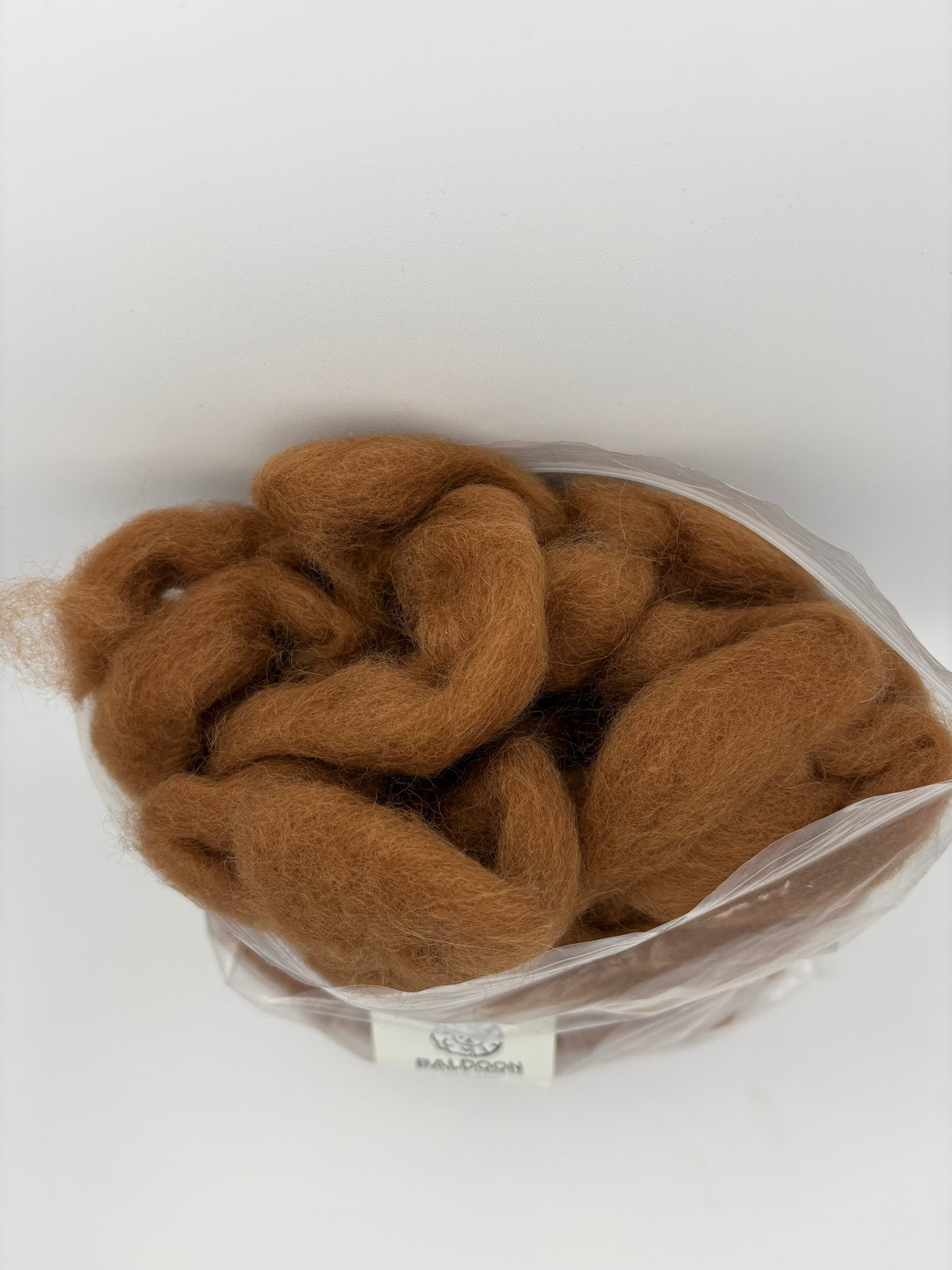 Brown alpaca roving rosette-style in clear plastic bag
