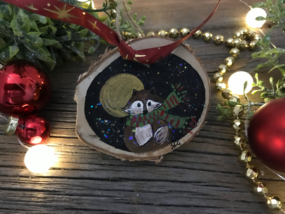 Hand-painted wooden raccoon ornament: round slice with painted moon and candy cane