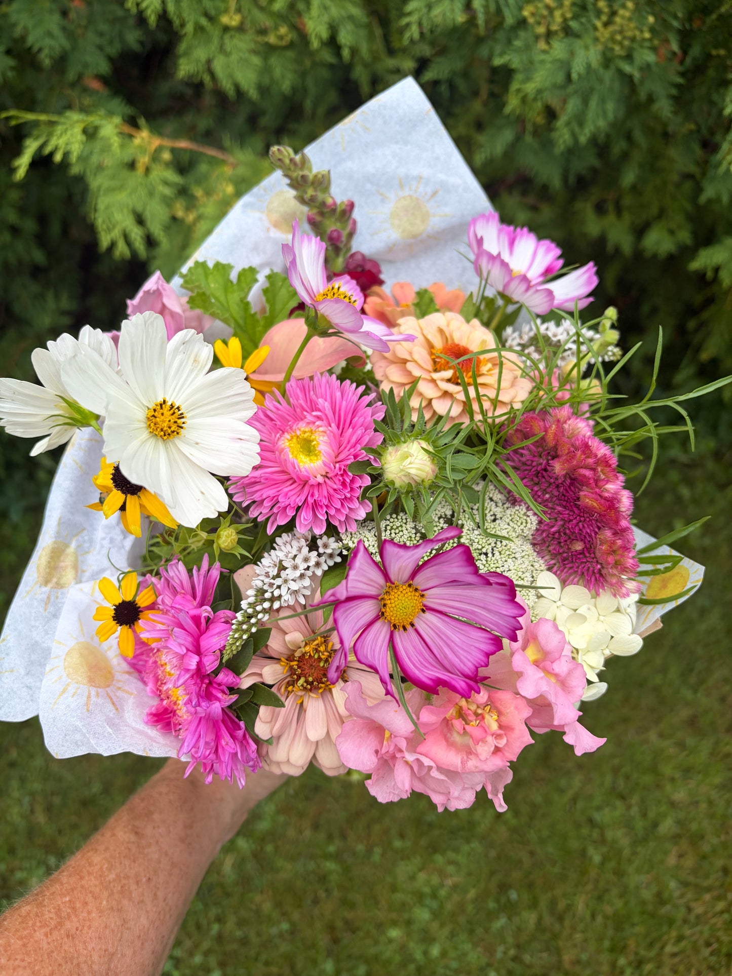 Pink and purple flower bouquet with daisies and carnations, wrapped in light paper