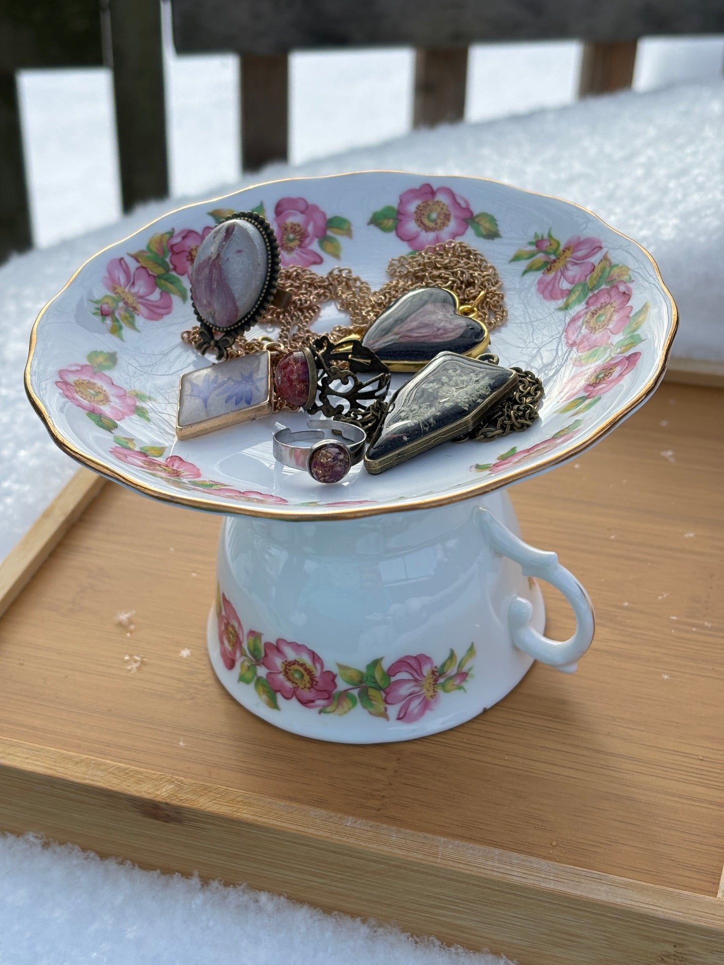 Tea cup jewelry holder with pink floral cup and saucer holding earrings and pendants