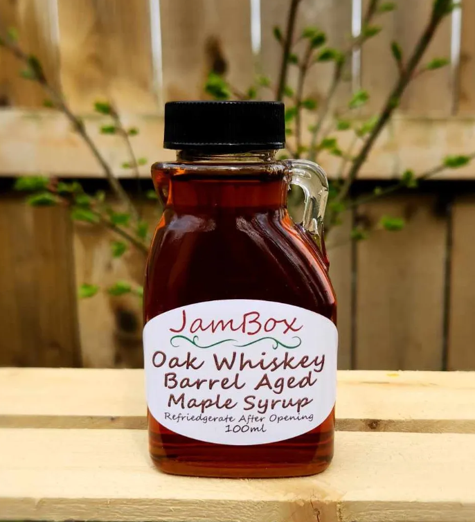 Oak barrel-aged maple syrup in a small amber glass bottle with black cap, 100 mL
