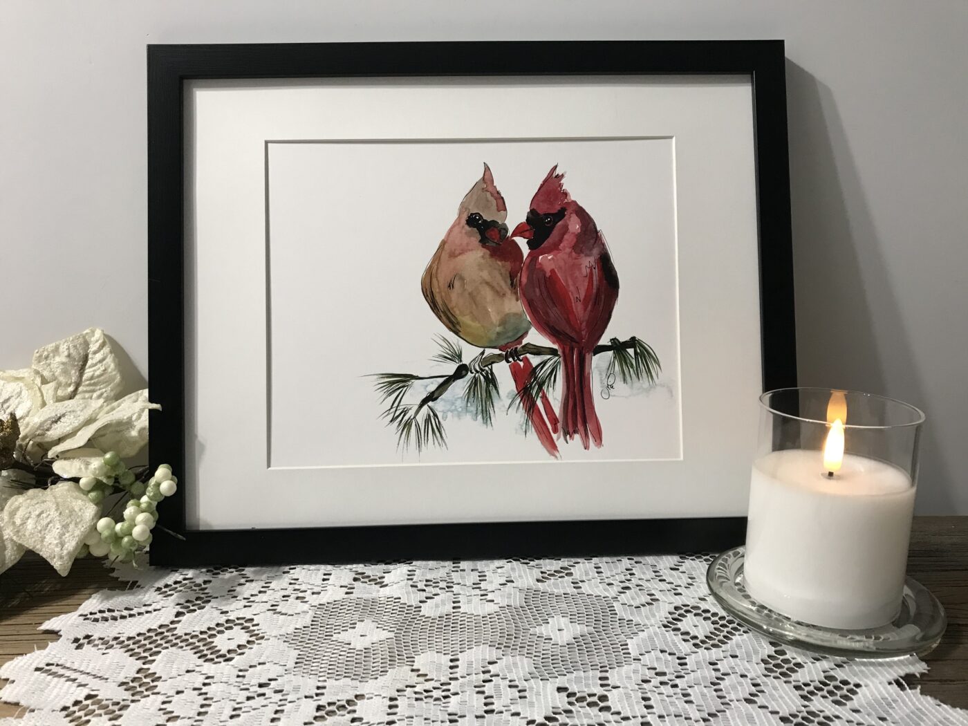 Framed wall art with two red cardinals perched on a branch