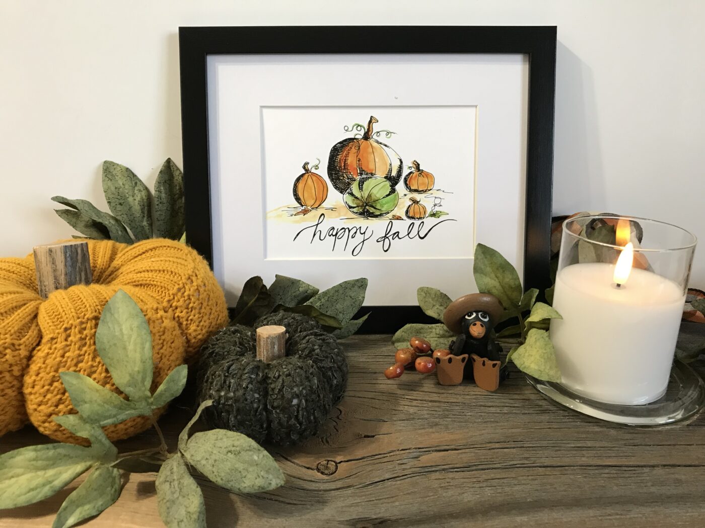 Framed fall wall art with horizontal pumpkins and cursive 'happy fall' text