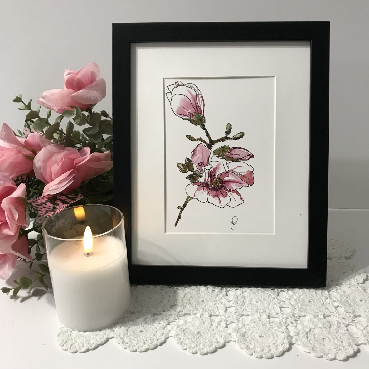 Framed floral artwork with pink magnolia blossoms and green stems