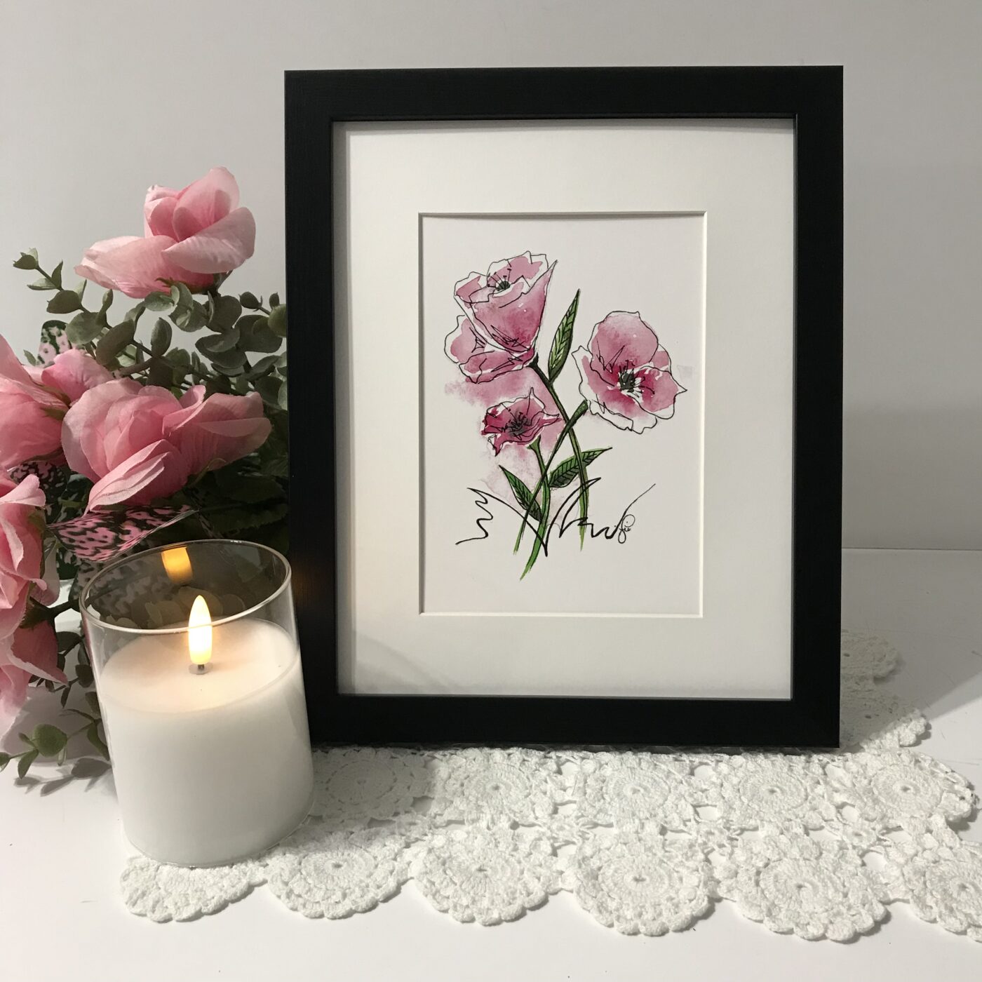 Framed print of three pink flowers with green stems on white background