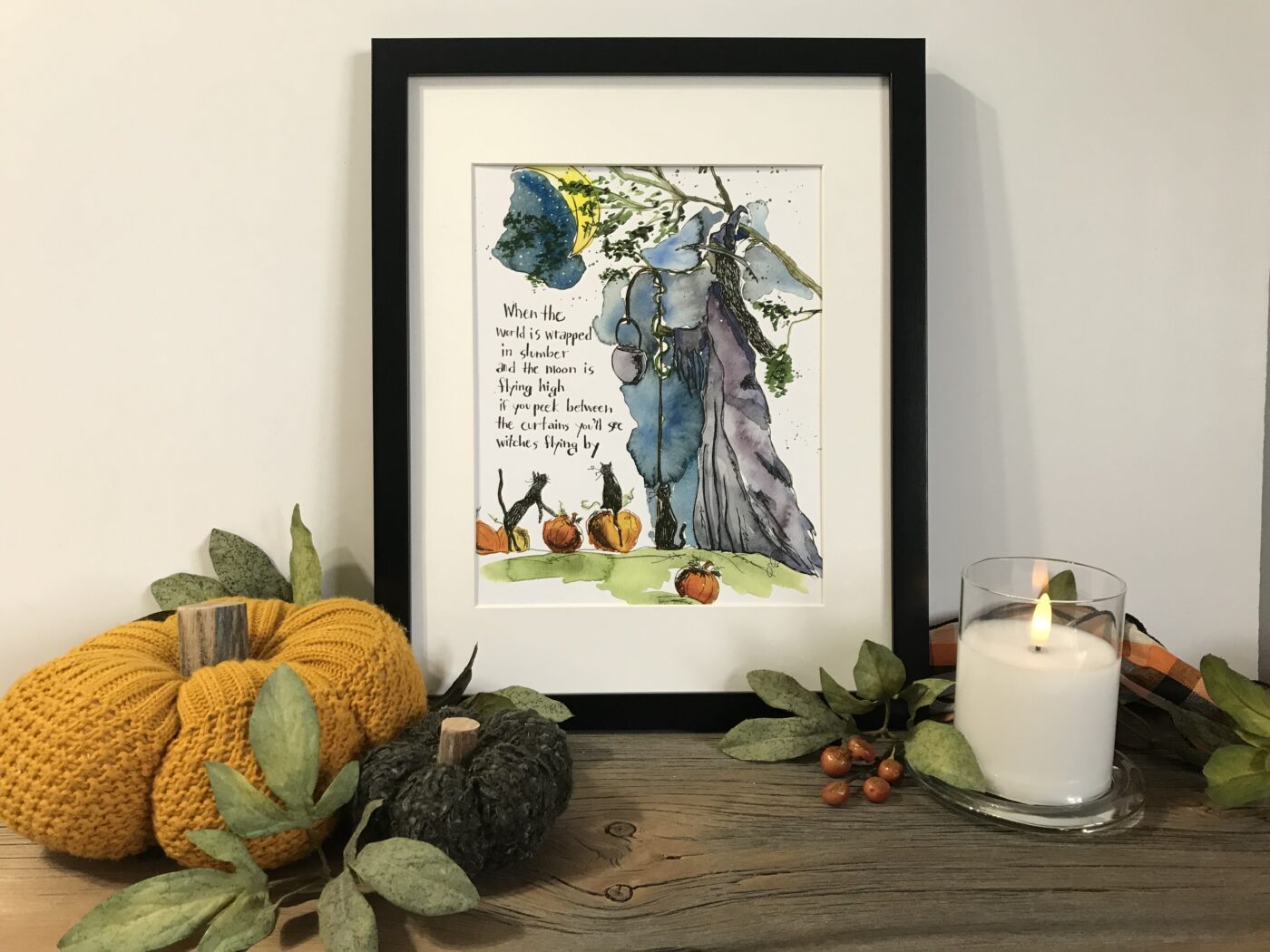 Framed watercolor wall art with a girl in a purple dress and fall pumpkins