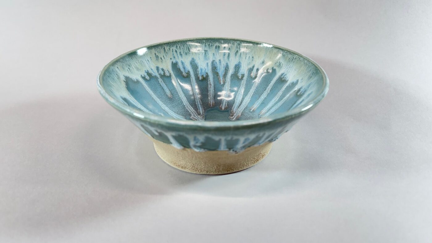 Turquoise ceramic bowl with white stripe pattern and beige base