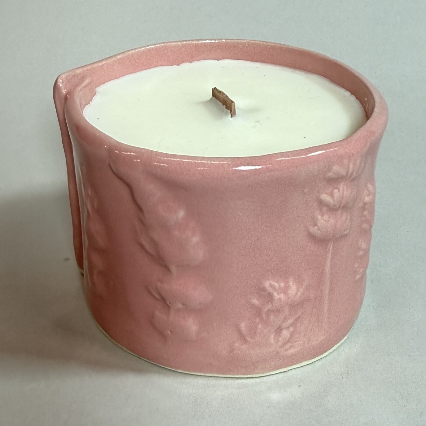 Erie Shores candle in pink embossed ceramic with white wax top and wooden wick