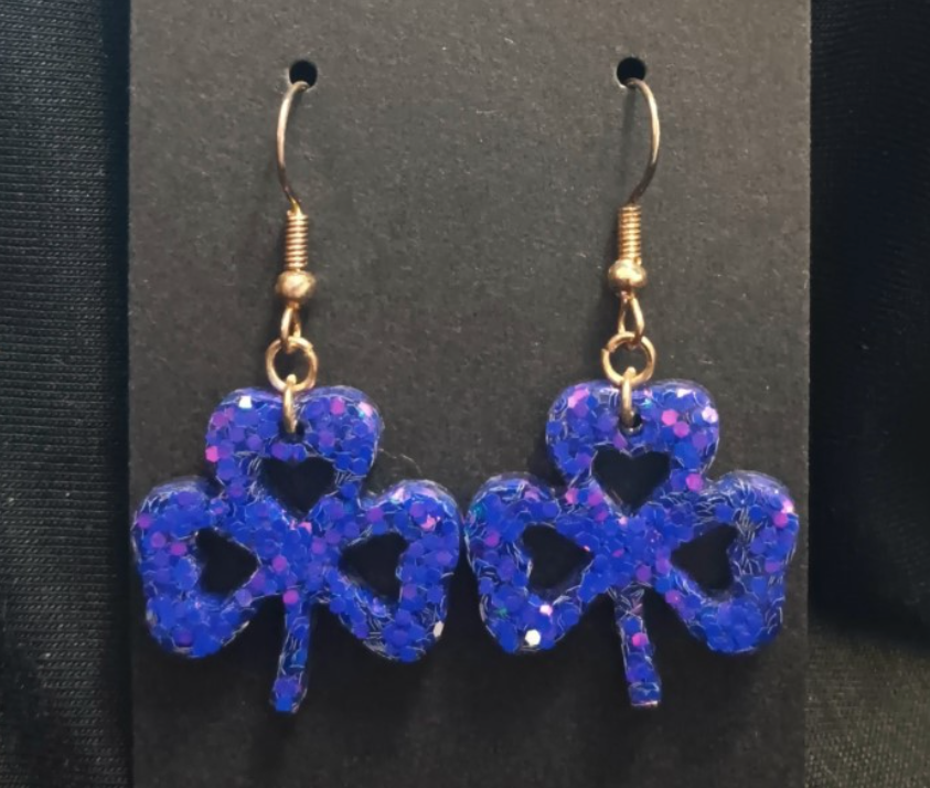Blue glitter clover dangle earrings with black heart charm and gold-tone hooks