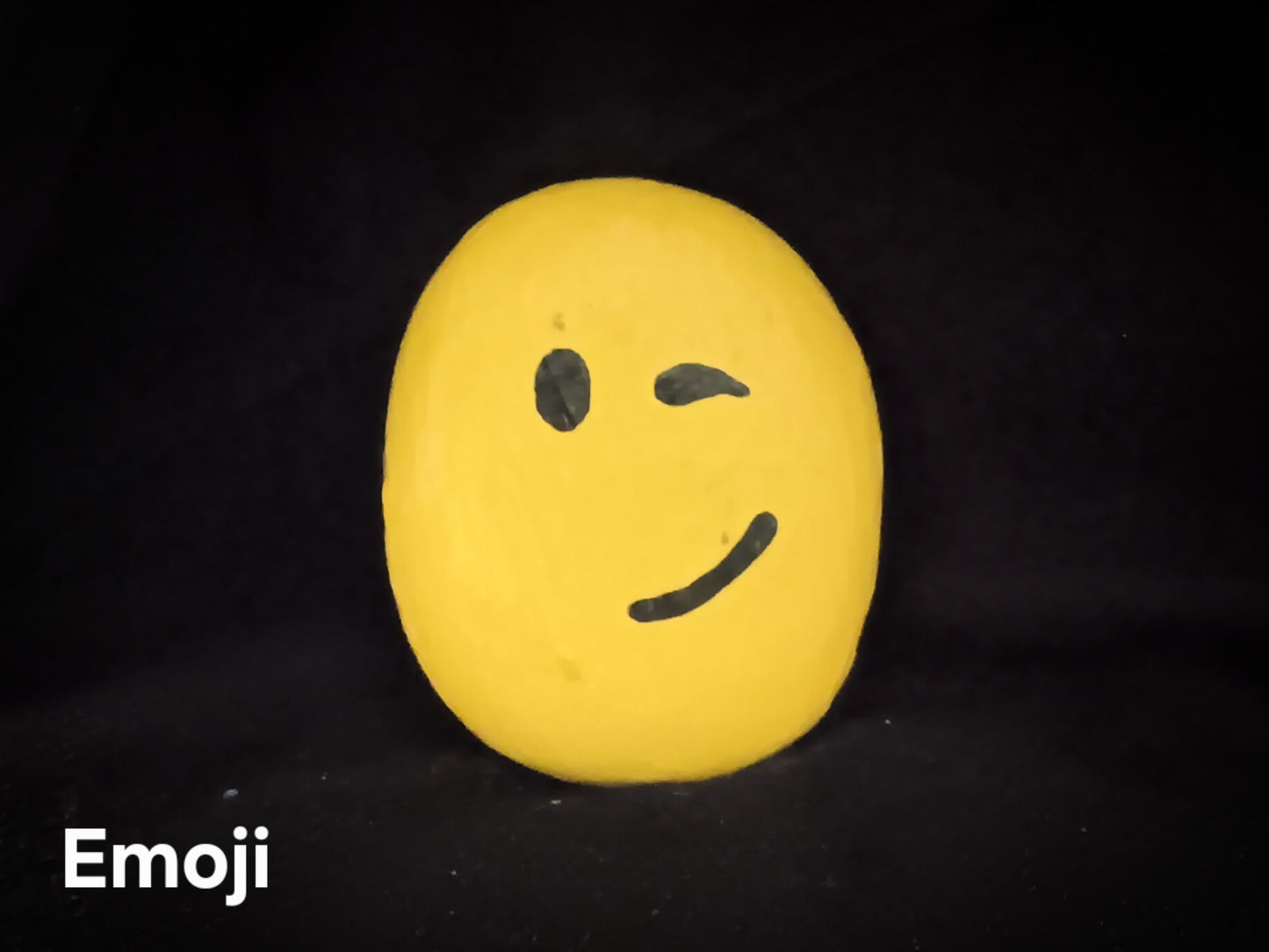 Emoji small decorative rock with yellow face and simple black features