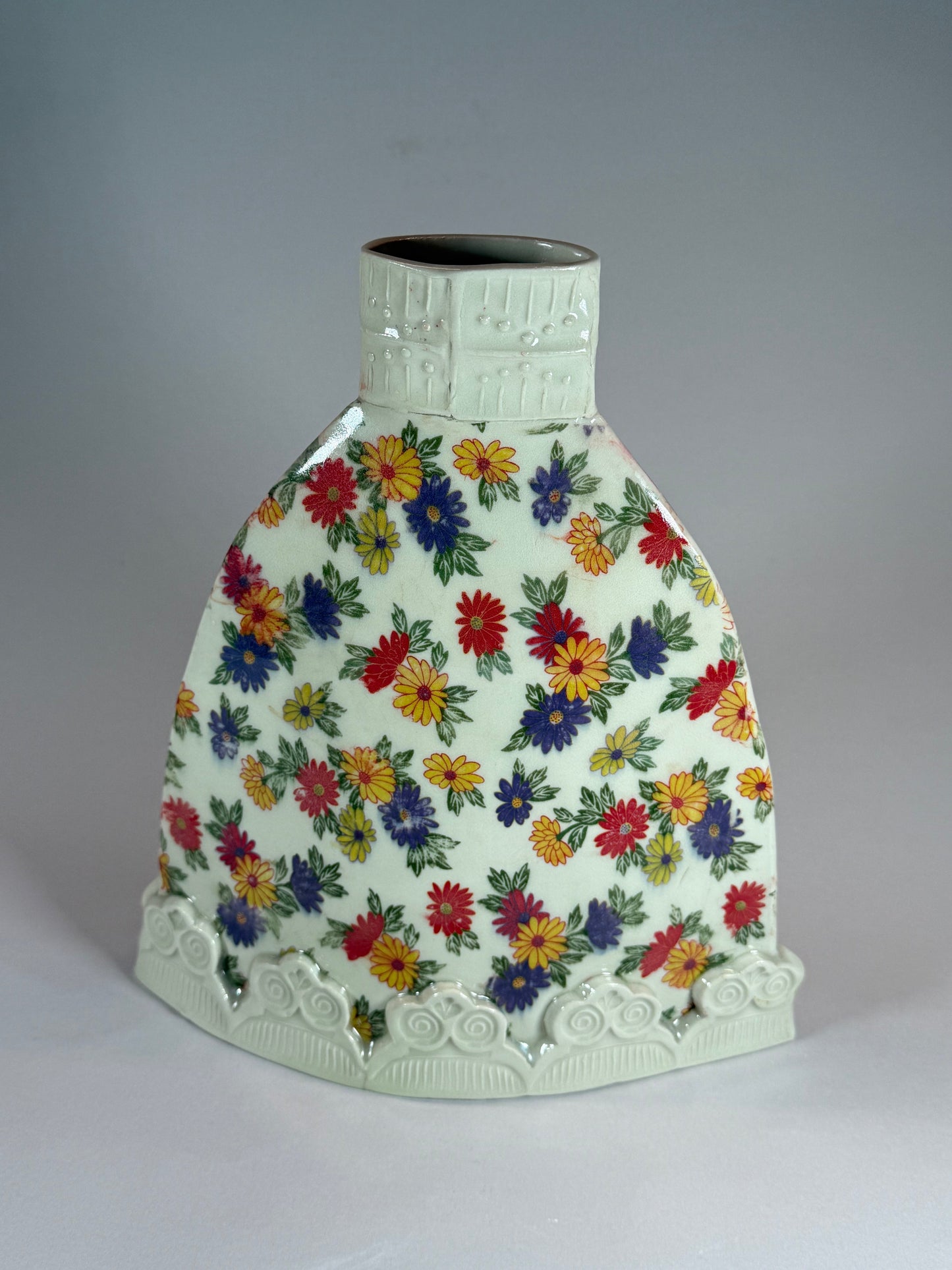 Flattie vase, white ceramic with colorful floral print and embossed scalloped base