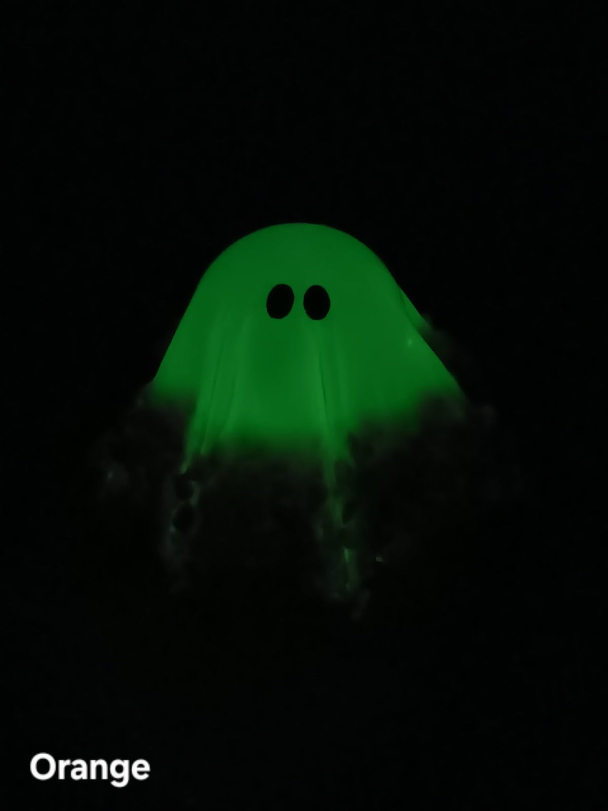 Glow-in-the-dark ghost figurine glowing green, hooded shape with black eyes, medium