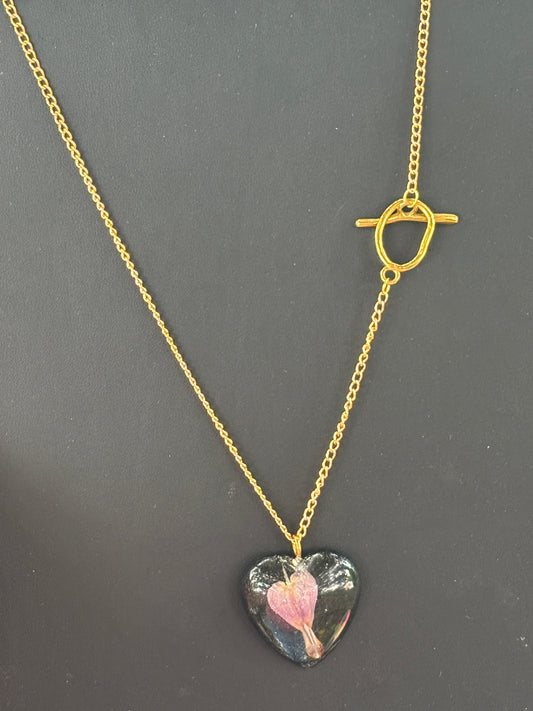 Bleeding Heart In Black Heart on Gold Sunglasses Holding Necklace