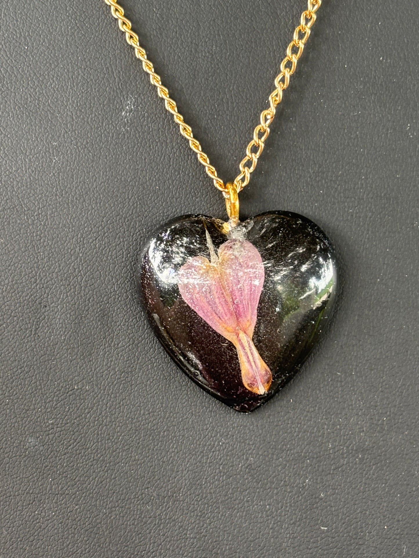 Bleeding Heart In Black Heart on Gold Sunglasses Holding Necklace