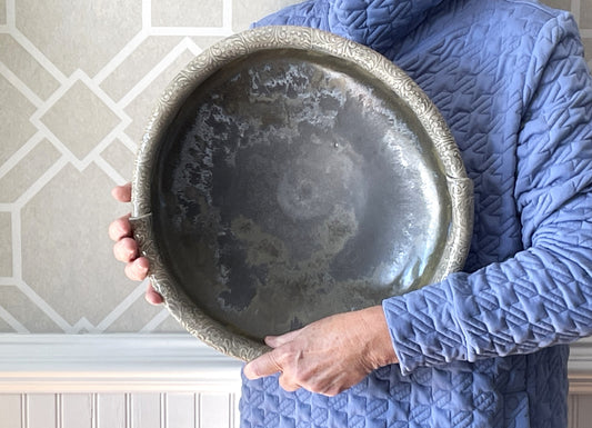 Decorative serving bowl with embossed silver edge and dark gray mottled interior, held up