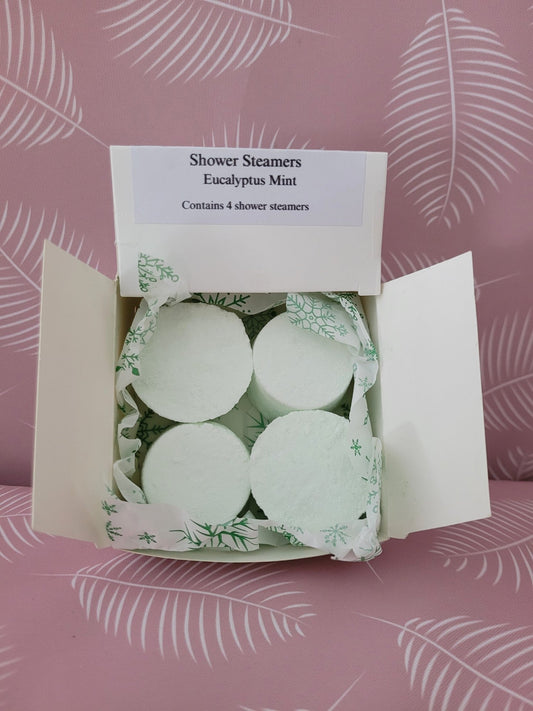 Shower steamer tablets in open box, mint-green and white with leaf pattern