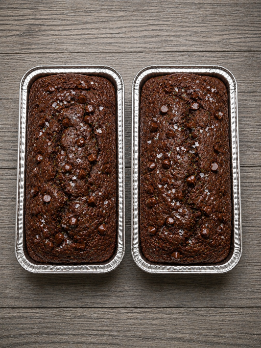 Chocolate zucchini bread mini loaves in metal pans, dark brown speckled crust