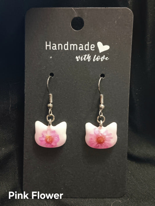 Pink cat dangle earrings with flower-shaped charms and silver-tone hooks