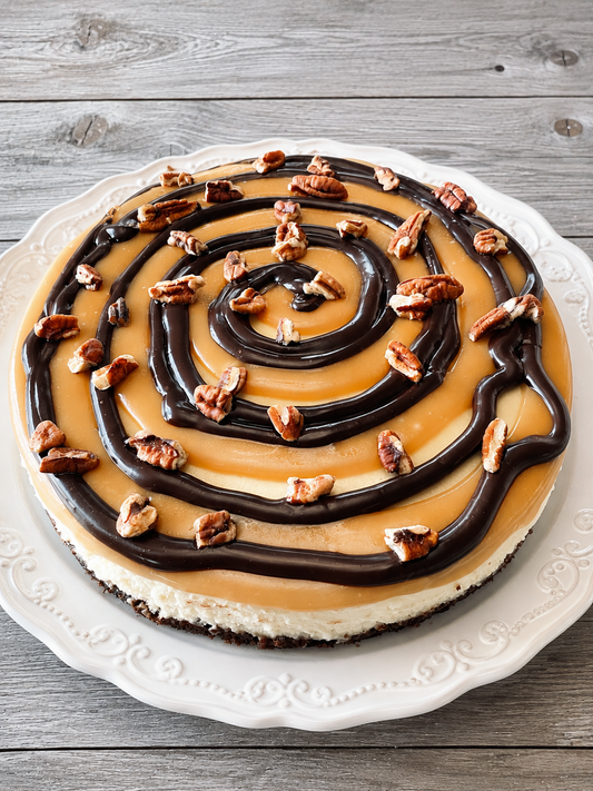 Classic New York turtle cheesecake with caramel and chocolate swirls, topped with nuts