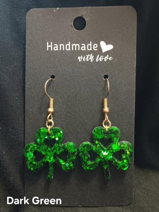 Dark green clover dangle earrings with heart cutouts and gold-tone hooks.