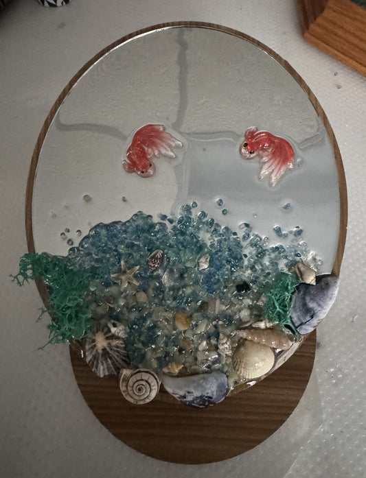 Decorative resin fish pond wall art with red fish, blue water, and seashell accents
