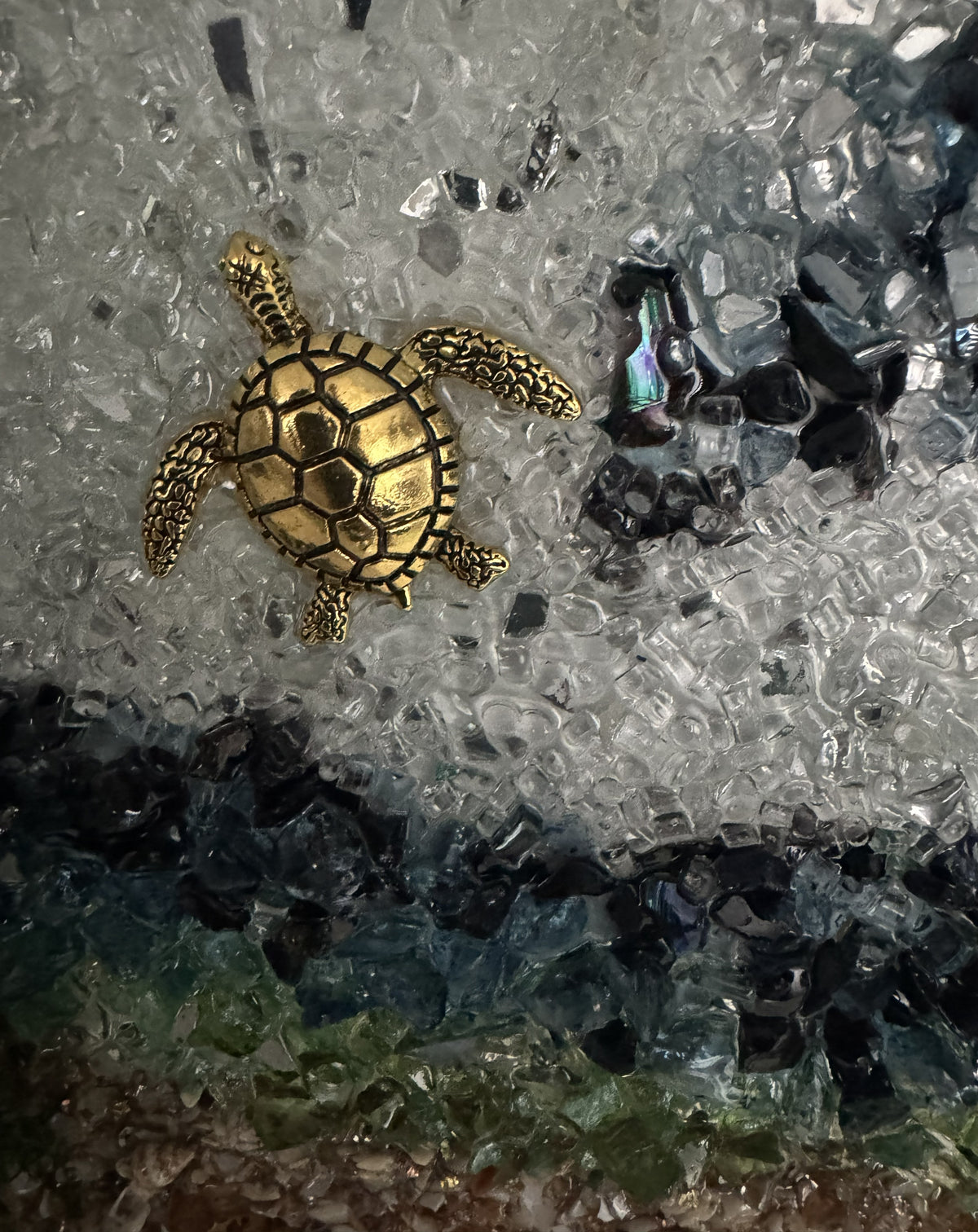 Golden sea turtle figurine with textured shell in clear resin wave
