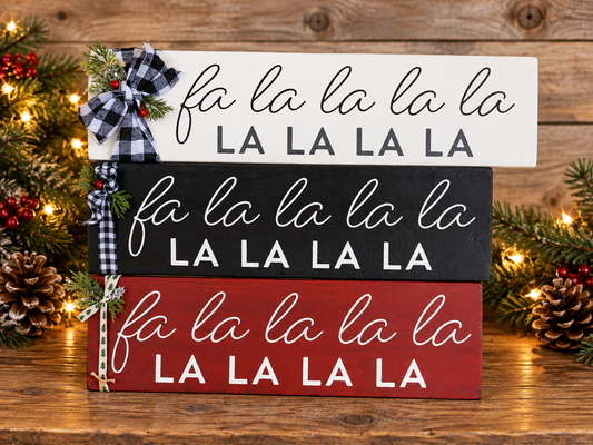 Stacked holiday Fa La La decor signs, white, black, and deep red with printed text