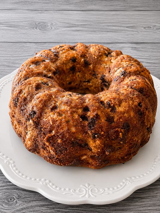 Banana bread ring loaf with dark golden-brown crumb on a white serving plate