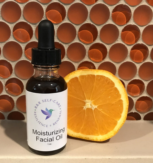 Moisturizing facial oil bottle with dropper and label, dark glass; orange slice beside it