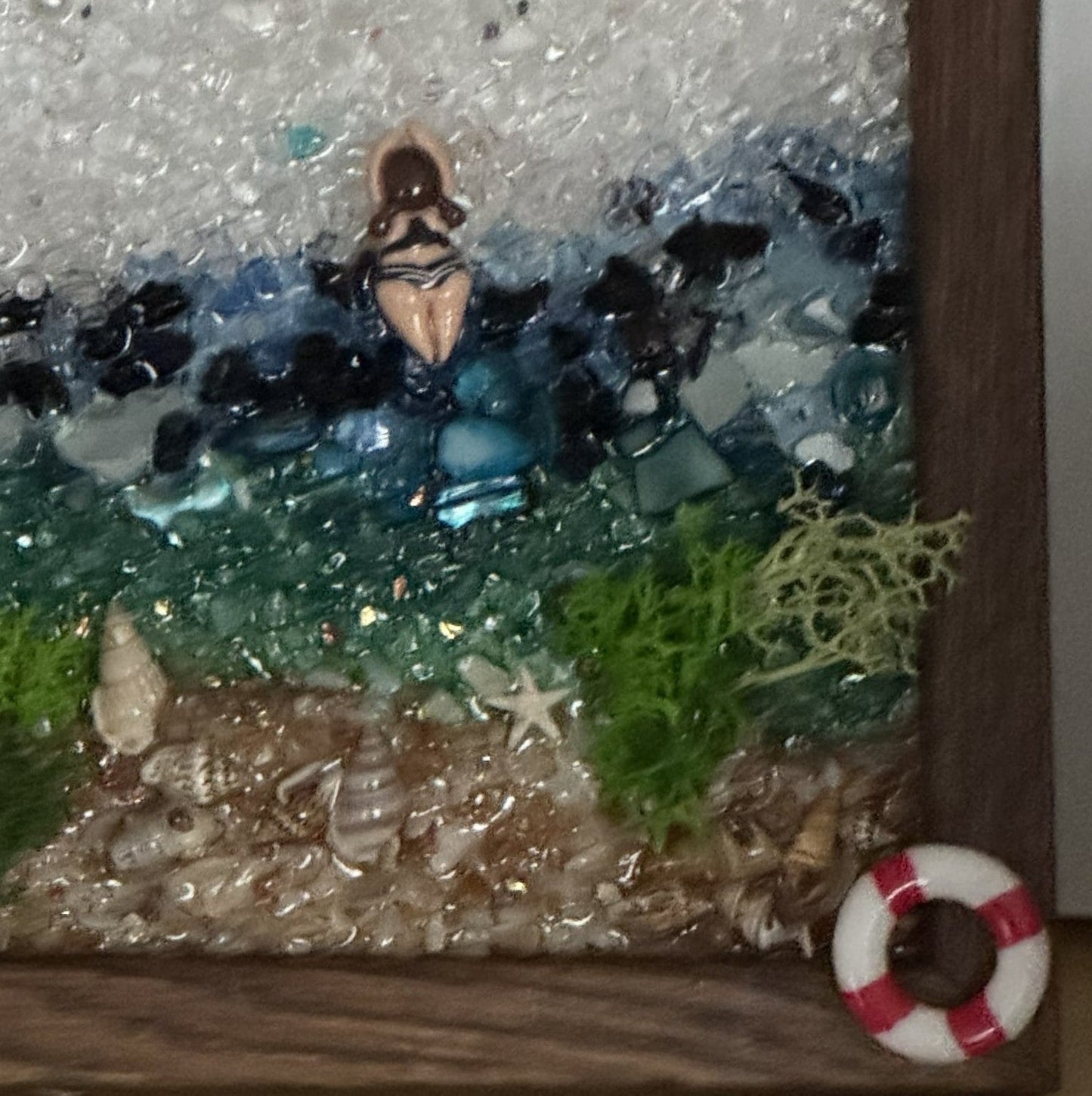 Ocean-themed framed wall art close-up with mermaid, blue stones, green seaweed, sand