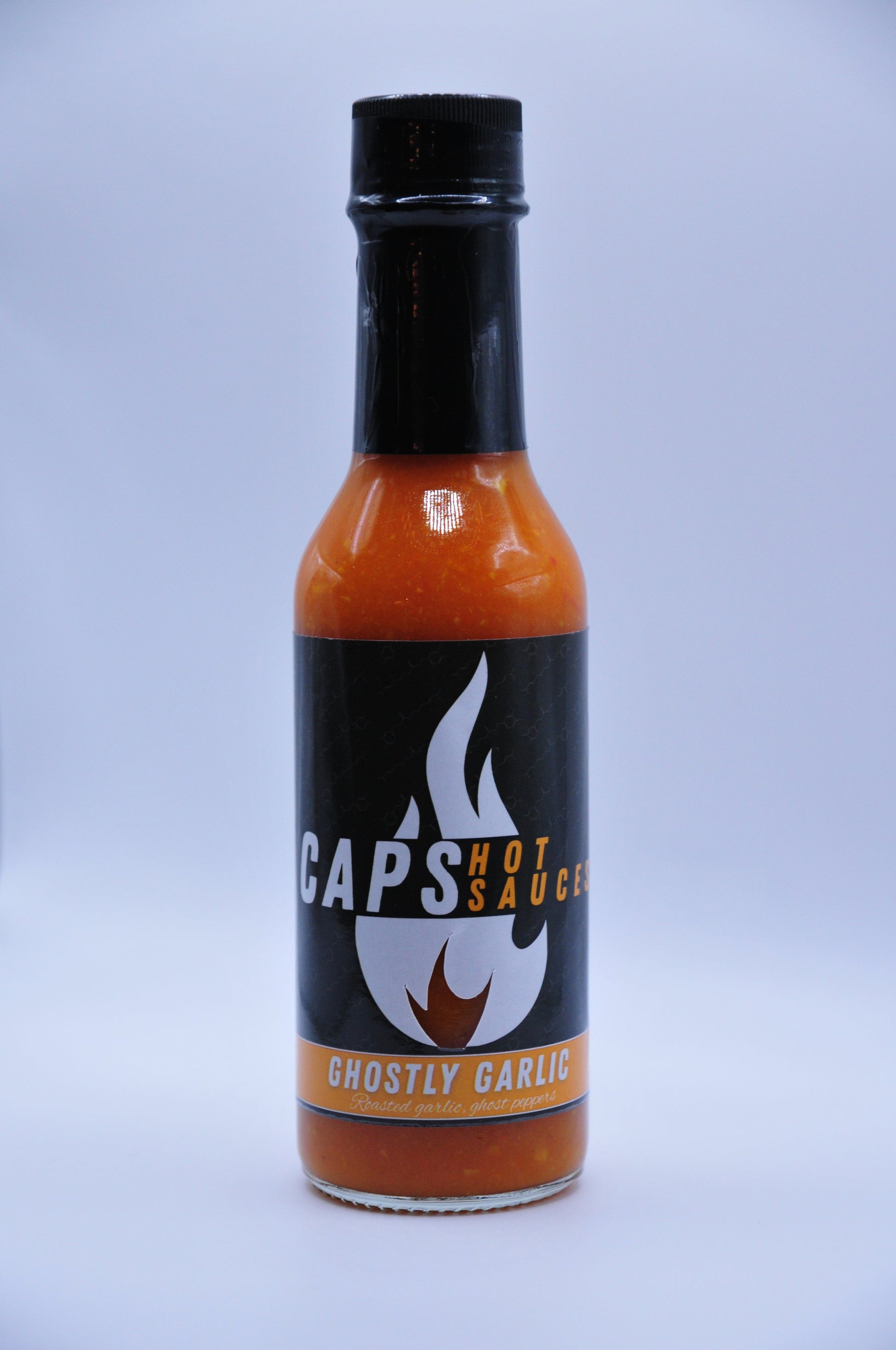 Black hot sauce bottle with orange front label and white flame graphic; garlic wording