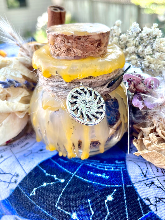 Glass spell jar with yellow wax seal and silver sun-faced charm, cork top
