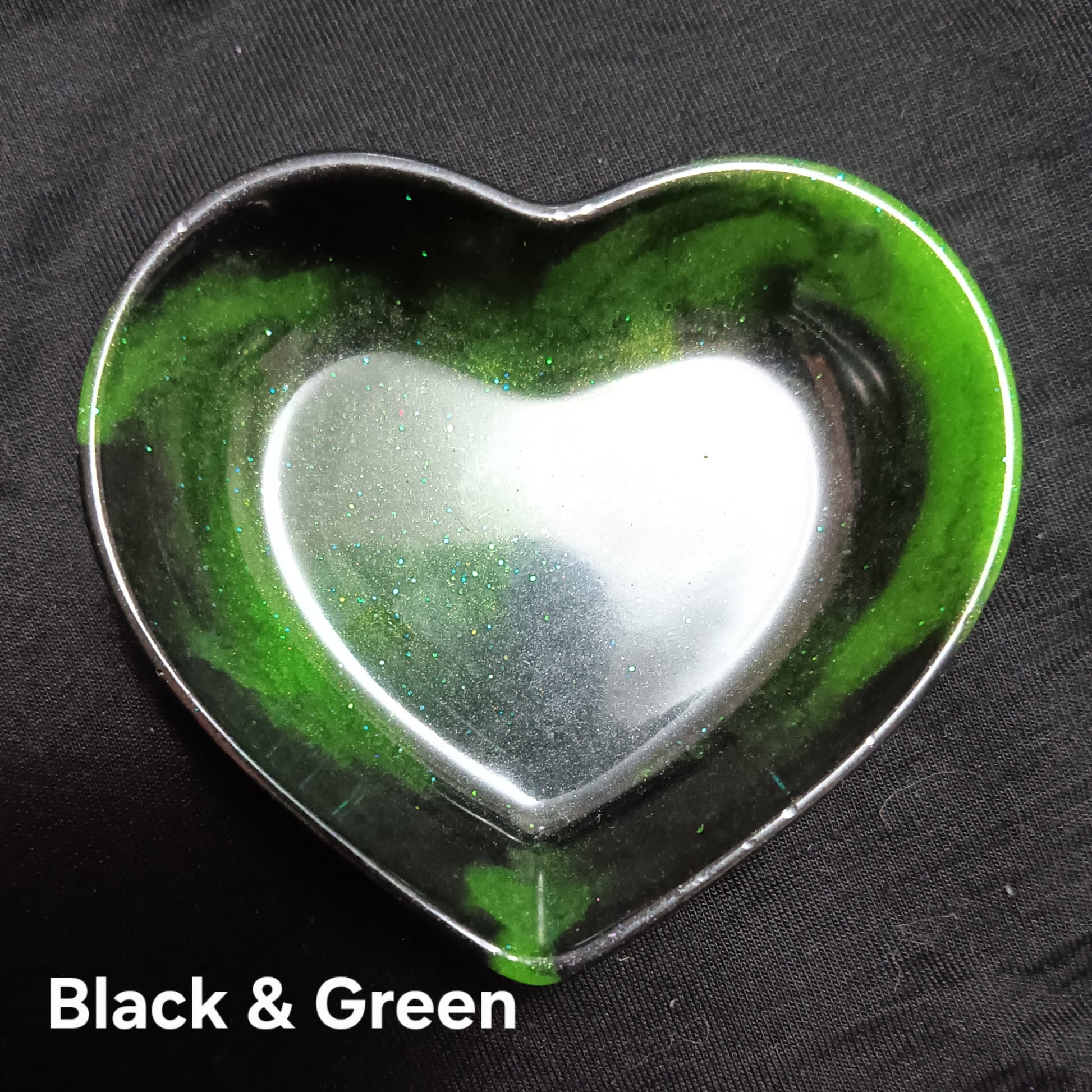 Black and green heart-shaped dish with bright green rim and clear inner glow.