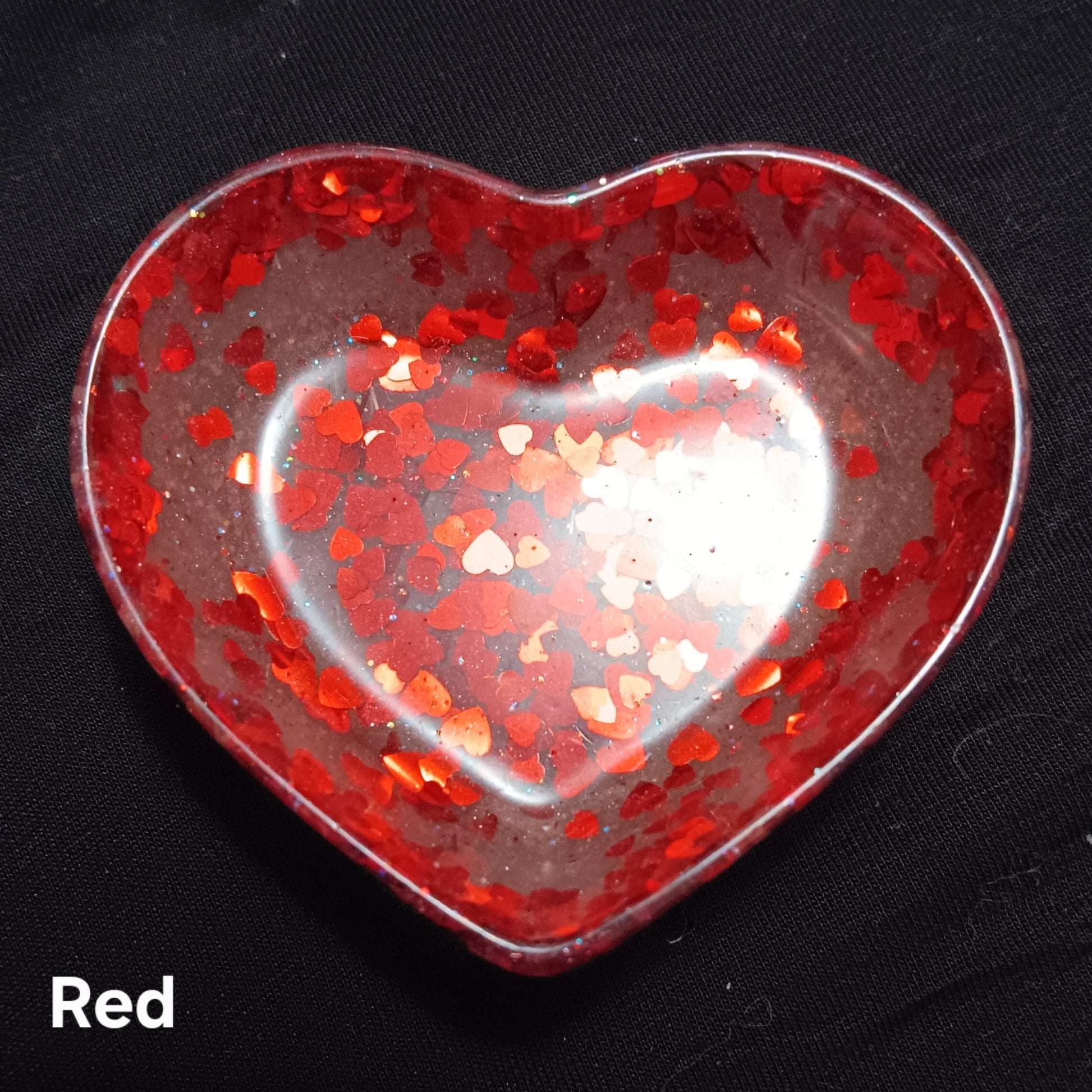 Red heart-shaped dish with embedded sparkle flecks and glossy finish.
