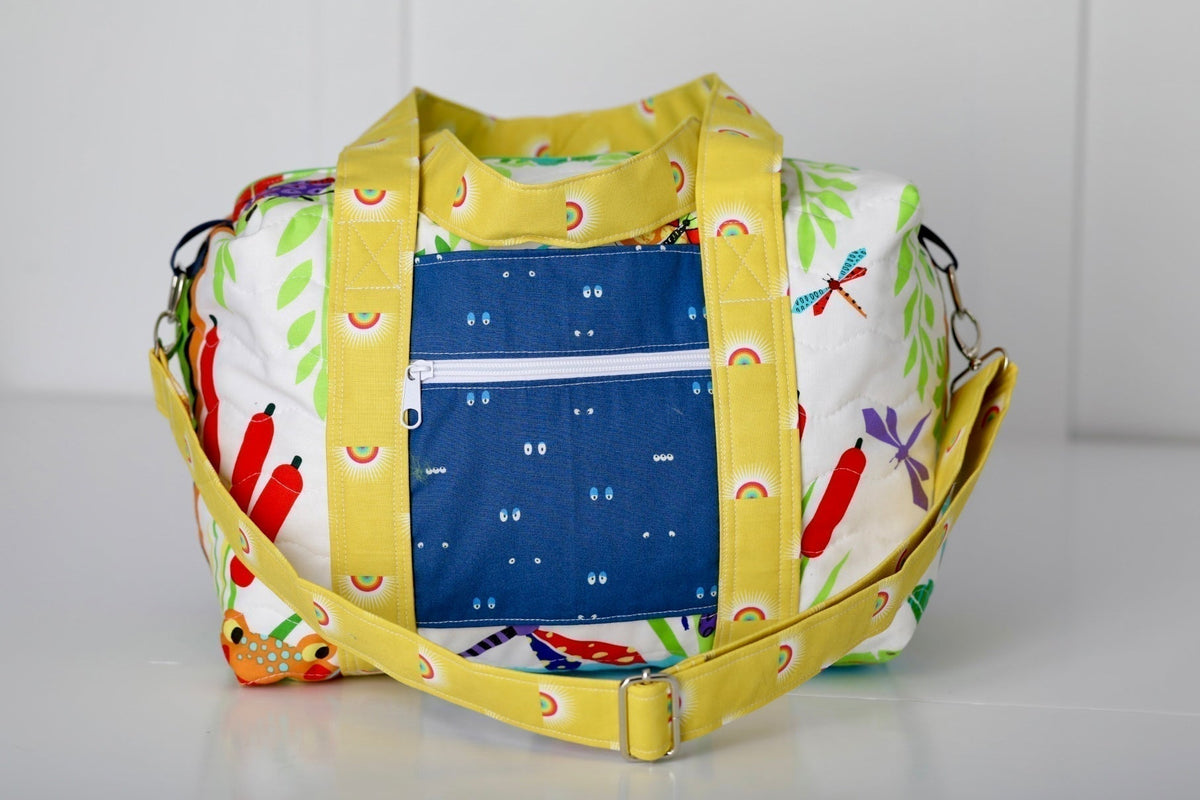 Kids duffle bag with yellow trim and multicolor animal print, top zipper