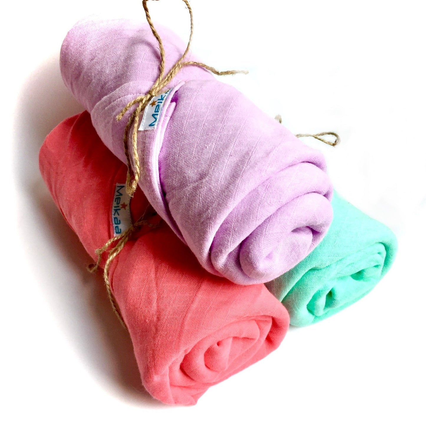 Assorted pastel swaddle blanket rolls: lilac, coral, pink, and teal