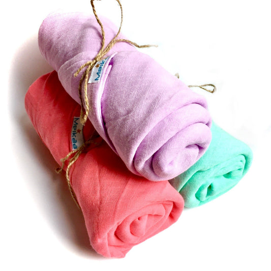 Assorted pastel swaddle blanket rolls: lilac, coral, pink, and teal