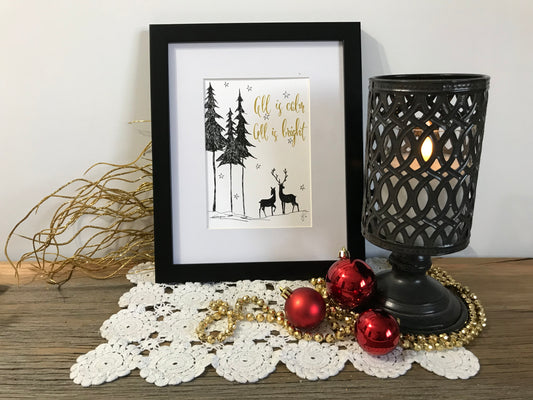 Framed winter holiday wall art with deer, pine trees, and gold lettering