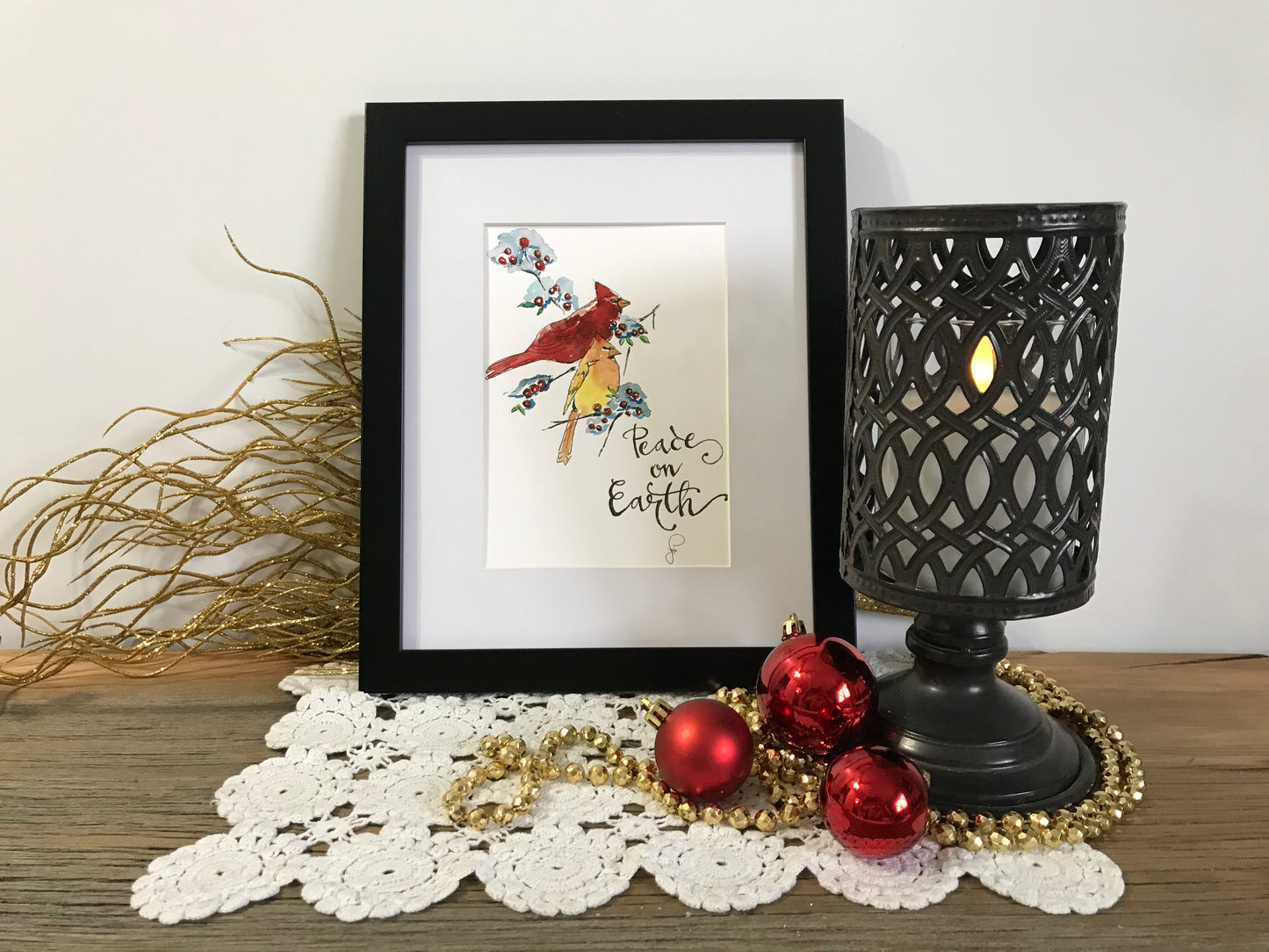 Framed holiday bird illustration with script text "Peace on Earth"