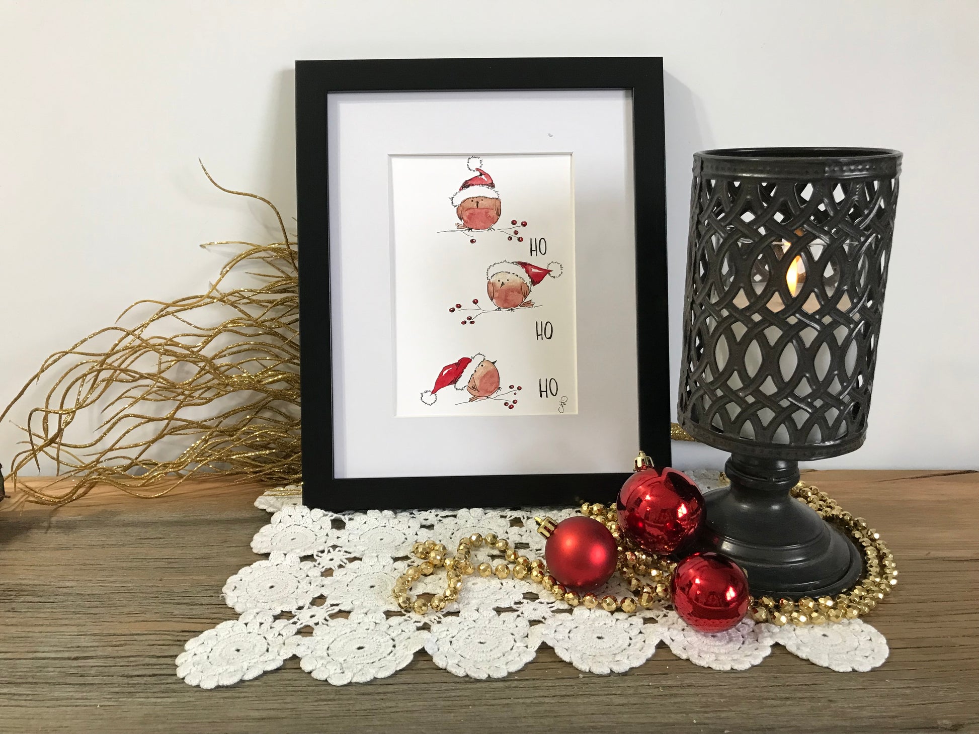 Framed holiday wall art with Santa and red ornaments in black border