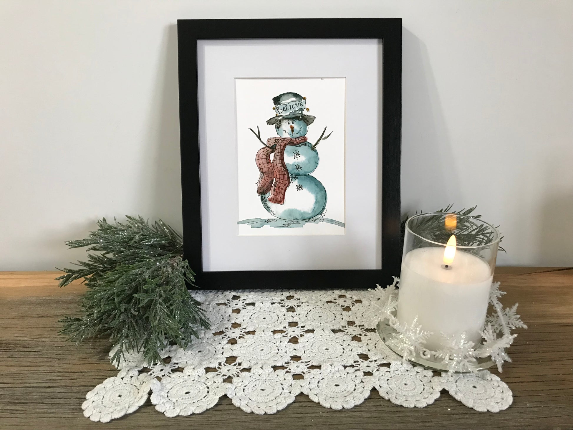 Snowman wall art print in a black-framed display