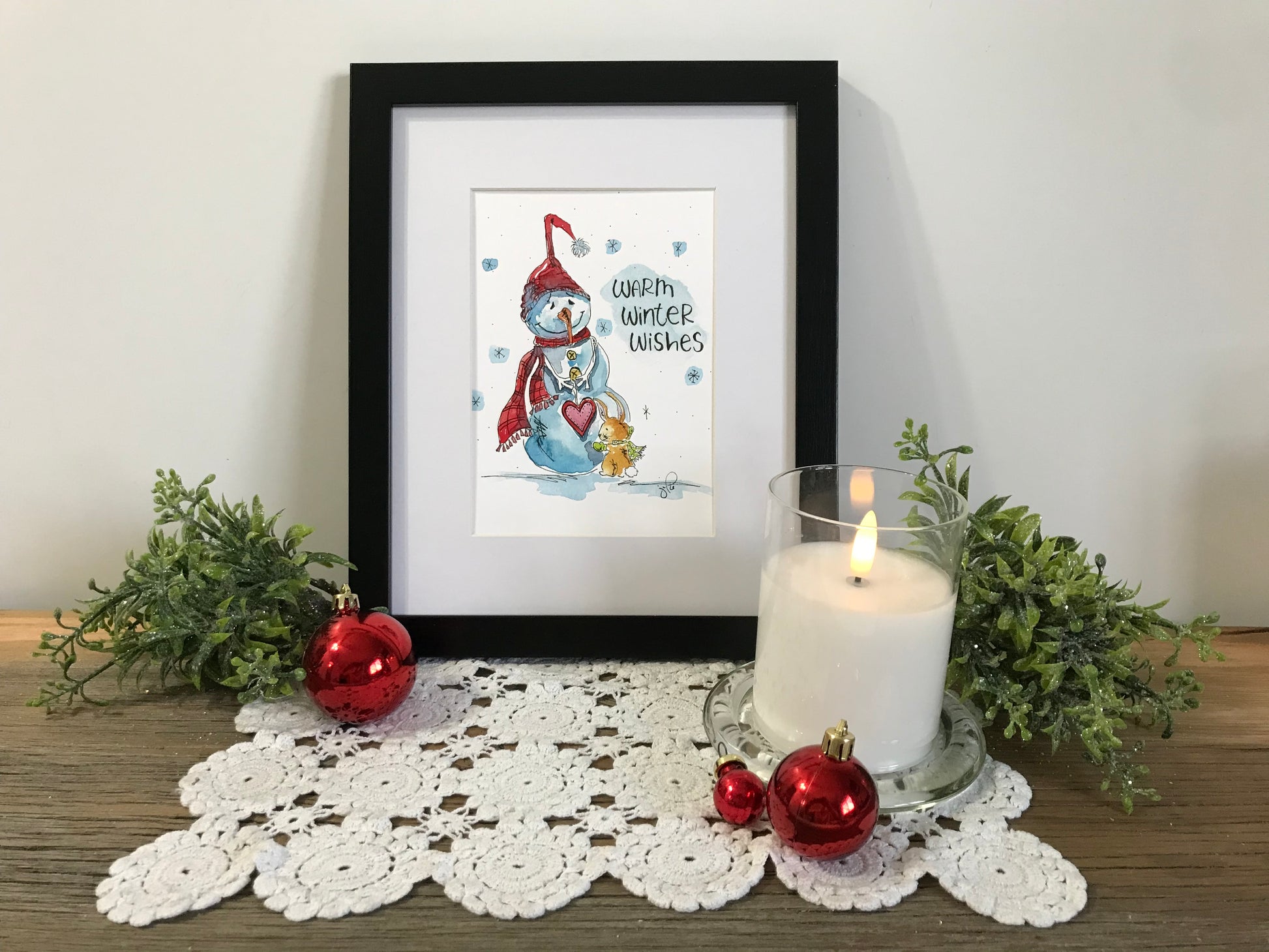 Framed winter illustration print with blue figure, red heart, and wish text
