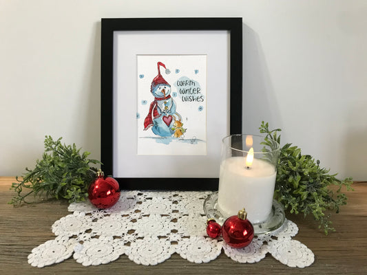 Framed winter illustration print with blue figure, red heart, and wish text