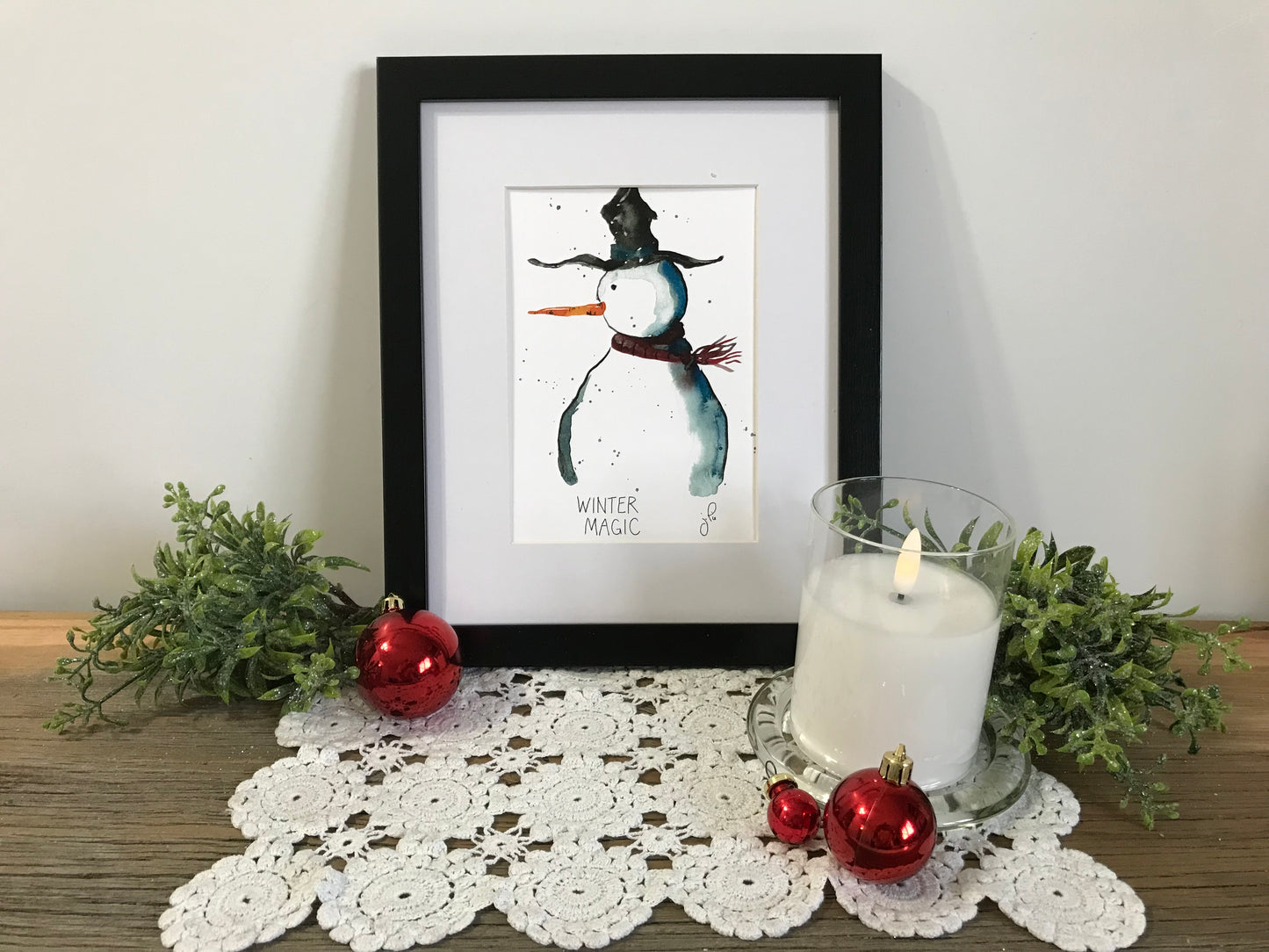 Framed Winter Magic wall art with illustrated snowman and scarf, standing pose